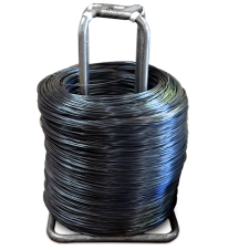 Large coil of black wire on a metal dispenser stand, used for recycling and packaging supplies.