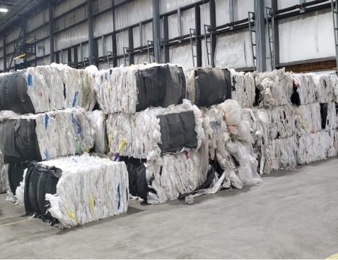 Bales of plastic feedstock stored in a recycling facility, ready for processing and reuse in the circular economy.