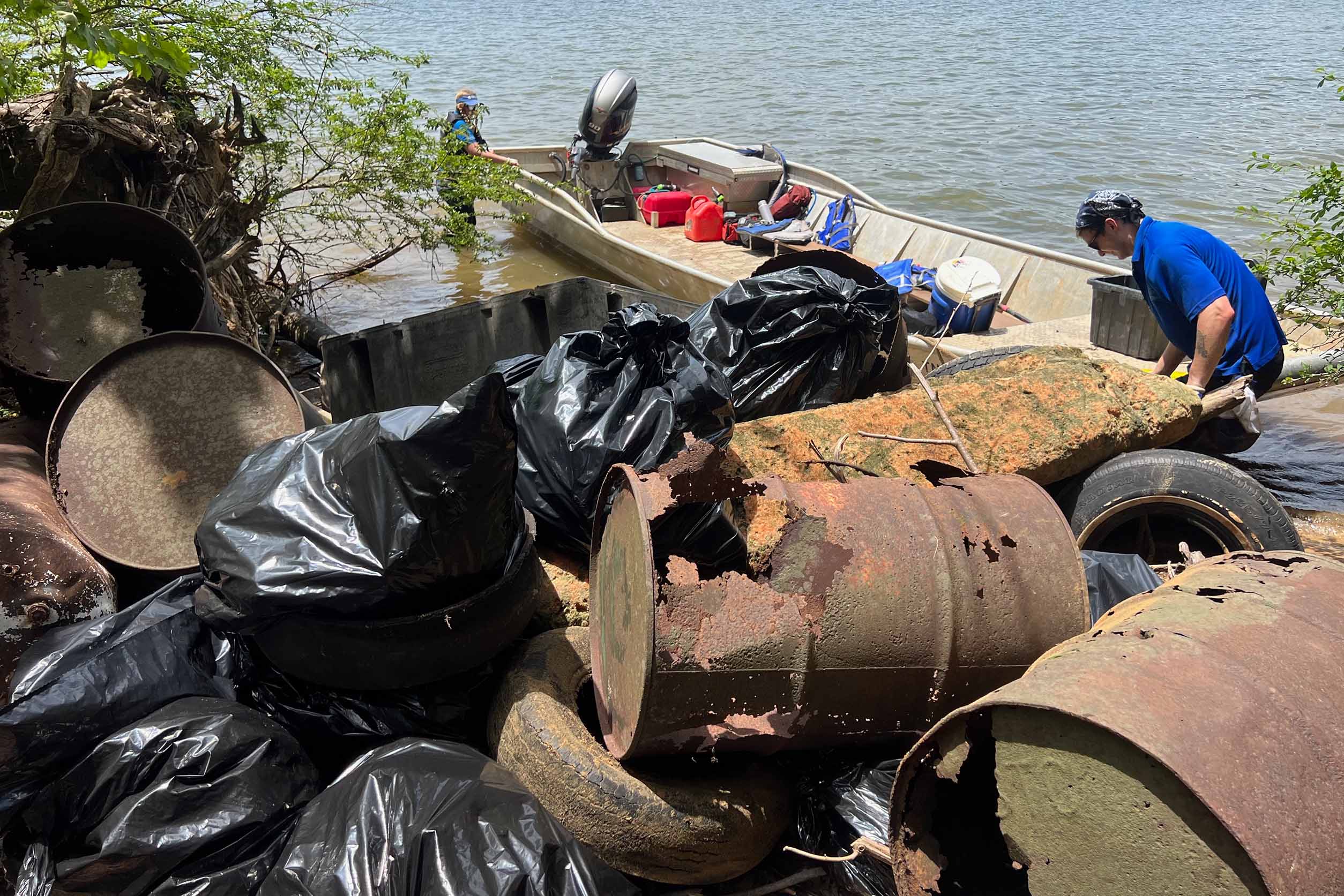 A volunteer picks up a discarded barrel during the 2025 Chickamauga Lake clean up presented by iSustain.